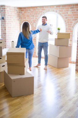 Karton kutular etrafında yeni evde dans genç güzel çift