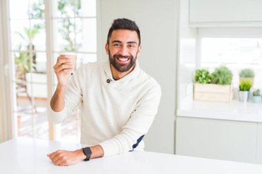 Sabah kahve almak içmek zevk sırasında gülümseyen yakışıklı adam
