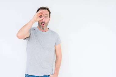 Sürpriz yüz, göz parmaklarının arasından seyir ile üst düzey yakışıklı ok jest yapıyor izole arka plan üzerinde şok. İmansız ifade.