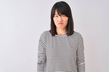 Genç güzel Çinli kadın izole beyaz arka plan üzerinde siyah çizgili t-shirt giyen depresif ve sıkıntı için endişe, kızgın ve korkmuş ağlıyor. Hüzünlü ifade.