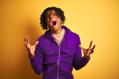 Izole mor arka plan üzerinde mor sweatshirt giyen dreadlocks ile Afro Amerikan adam deli ve deli bağırarak ve agresif ifade ve kollar kaldırdı ile bağırıyor. Hayal kırıklığı kavramı.