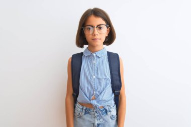 Güzel öğrenci çocuk kız yüzünde ciddi ifade ile izole beyaz arka plan üzerinde sırt çantası ve gözlük giyiyor. Kameraya basit ve doğal bir bakış.