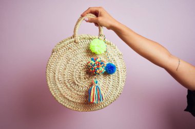 Hasır çanta tutan kadının eli