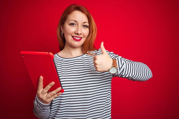 Giovane Bella Rossa Donna Utilizzando Tablet Sfondo Rosso Isolato Felice — Foto Stock