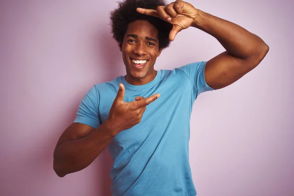 青いTシャツを着たアフリカ系アメリカ人男性は 孤立したピンクの背景の上に立って 幸せそうな顔で手と指でフレームを作ります 創造性と写真のコンセプト — ストック写真