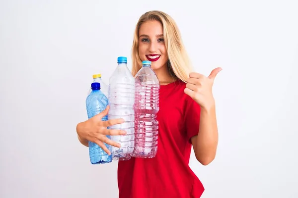 年轻美丽的女人回收塑料瓶站在孤立的白色背景快乐与大微笑做Ok标志 拇指用手指 优秀的标志 — 图库照片