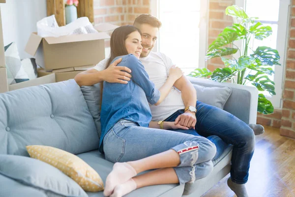 Schönes Paar, das sich verliebt auf dem Sofa umarmt, sehr glücklich lächelnd — Stockfoto