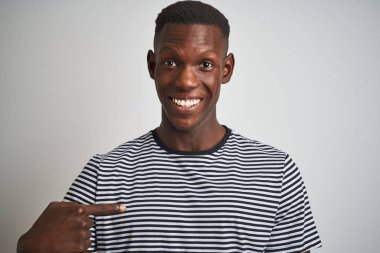 Kendini işaret sürpriz yüzü ile izole beyaz arka plan üzerinde duran lacivert çizgili t-shirt giyen Afrikalı Amerikalı adam