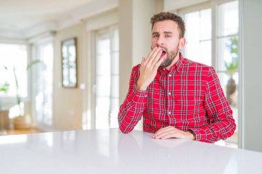 Renkli gömlek giyen yakışıklı bir adam ağzıyla esnemekten sıkılmış. Huzursuz ve uykulu..