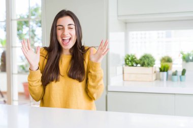 Kızgın ve silah ile başarı için deli sarı kazak kutluyor giyen güzel genç kadın kaldırdı ve heyecanlı çığlık gözler kapalı. Kazanan kavramı