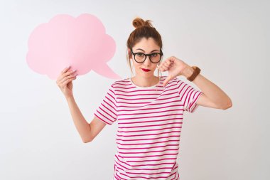 Kızgın yüz ile izole beyaz arka plan üzerinde bulut konuşma balonu tutan gözlük takan Kızıl saçlı kadın, başparmak aşağı, ret kavramı ile sevmediğimi gösteren negatif işareti