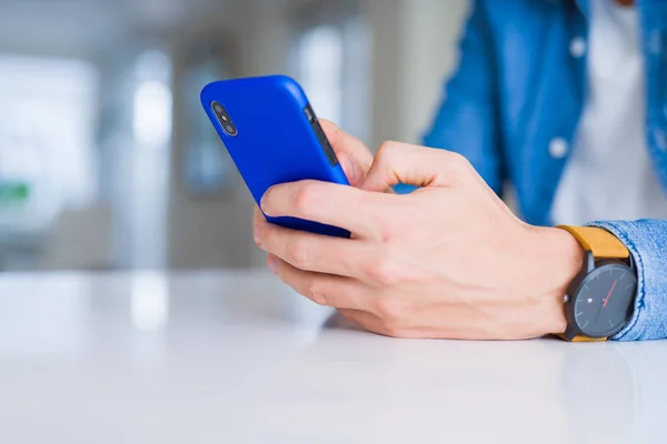 Primer plano de las manos del hombre usando el teléfono inteligente y sonriendo —  Fotos de Stock