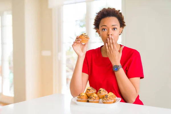 Unga Afroamerikanska Kvinnan Äter Chips Choklad Muffins Täcka Munnen Med — Stockfoto