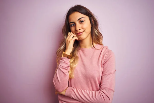 年轻美丽的女人穿着一件毛衣在粉红色的孤立背景与手下巴思考问题 沉思的表情 带着体贴的脸微笑 怀疑概念 — 图库照片