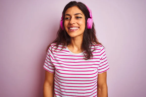 고립된 분홍색 헤드폰을 사용하여 음악을 아름다운 여성은 얼굴에 미소를 지으며 — 스톡 사진