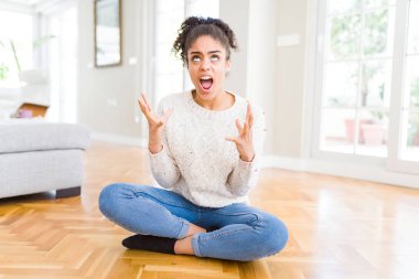 Kat çılgın ve kızgın bağırarak ve agresif ifade ve silah kaldırdı bağırmaya oturan afro saçlı güzel genç Afro-Amerikan kadın. Hayal kırıklığı kavramı.