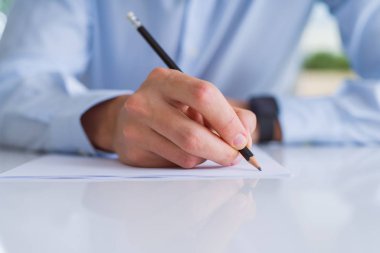 Adam el üzerinde beyaz kağıt bir kalem kullanarak yazma yakın çekim