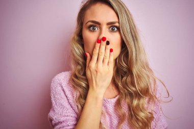 Pembe izole arka plan kapağı ağız üzerinde duran kazak giyen genç güzel kadın hata için utanç ile şok el ile ağız, korku ifadesi, sessizlik, gizli kavram korkmuş