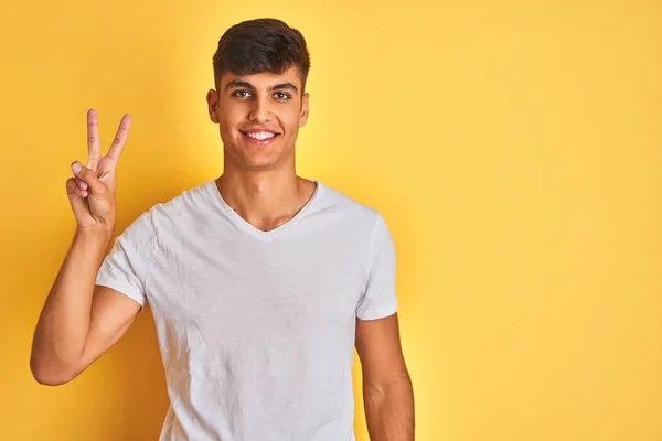 Homem Indiano Jovem Vestindo Camiseta Branca Sobre Fundo Amarelo Isolado — Fotografia de Stock