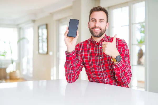 Hezký Muž Ukazuje Obrazovku Smartphone Šťastný Velkým Úsměvem Dělá Znamení — Stock fotografie