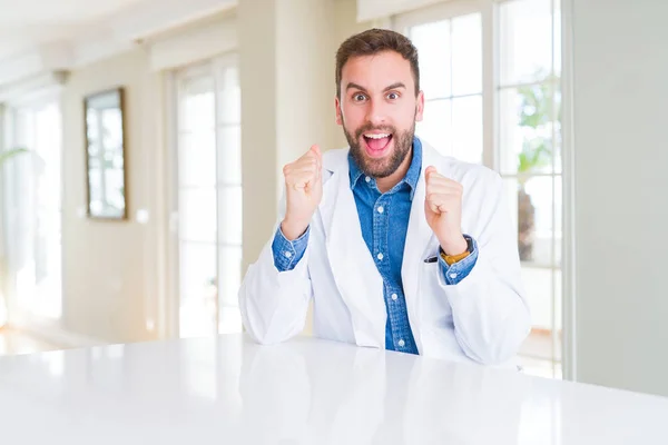 Όμορφος Γιατρός Φορώντας Ιατρικό Παλτό Στην Κλινική Γιορτάζει Έκπληκτος Και — Φωτογραφία Αρχείου