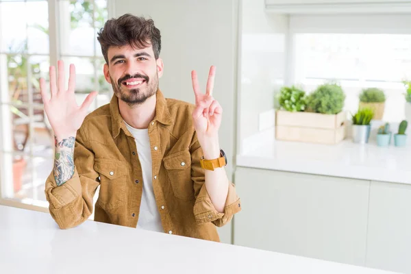 Hombre Joven Con Chaqueta Casual Sentado Mesa Blanca Mostrando Apuntando — Foto de Stock