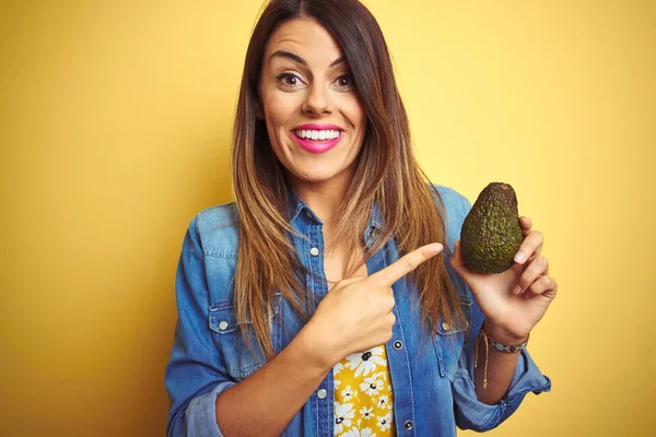 Jonge Mooie Vrouw Eten Gezonde Avocado Gele Achtergrond Zeer Gelukkig — Stockfoto