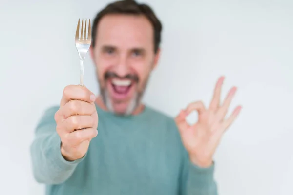 Senior Mann Hält Silberne Gabel Über Isolierten Hintergrund Tun Zeichen — Stockfoto