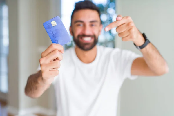 手と指で指し示す非常に幸せなクレジットカードを保持ハンサムなヒスパニックの男 — ストック写真
