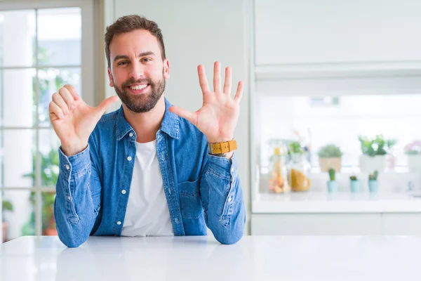 一个英俊的男人在家里用手指指着六号 面带微笑 自信而快乐 — 图库照片