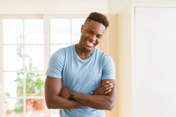 Beau jeune homme africain souriant gai avec les bras croisés — Photo