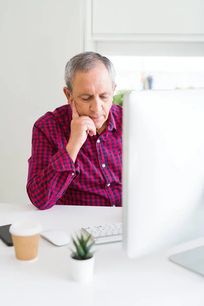 Hombre mayor guapo trabajando con computadora buscando concentrado — Foto de Stock