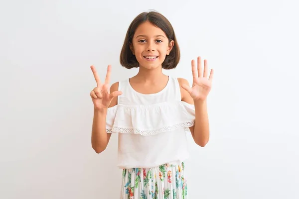 孤立した白い背景の上に立つカジュアルなドレスを着た若い美しい女の子は 自信を持って幸せに微笑みながら 指番号8を示し 指を上げる — ストック写真