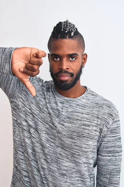 African american man with braids wearing grey sweater over isolated white background with angry face, negative sign showing dislike with thumbs down, rejection concept
