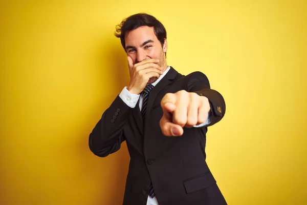 양복과 넥타이를 고립된 노란색 서있는 잘생긴 사업가가 당신을 비웃고 손가락을 — 스톡 사진