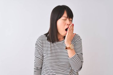 Izole beyaz arka plan üzerinde siyah çizgili t-shirt giyen genç güzel Çinli kadın el ile ağız kapsayan yorgun esneme sıkılmış. Huzursuz ve uykululuk.