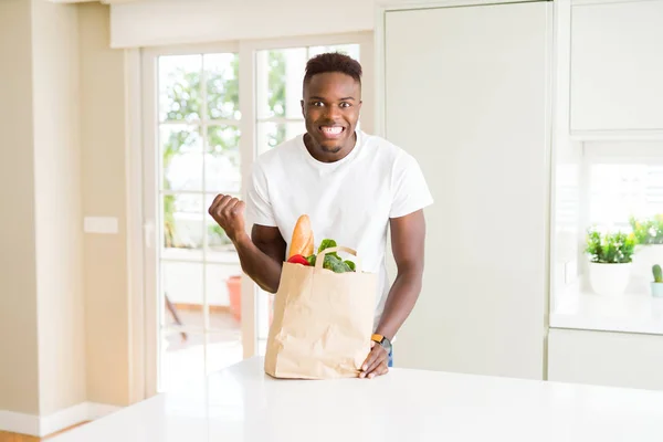 Afroameričan Který Drží Papírový Sáček Plný Čerstvých Potravin Vykřičí Oslavuje — Stock fotografie