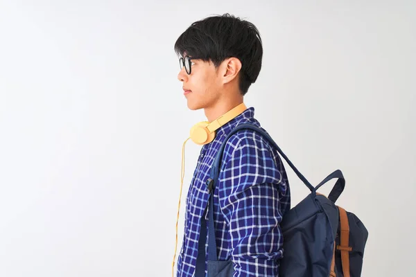 배낭과 헤드폰을 착용한 중국인 학생은 고립된 옆으로 보이고 자신감 미소로 — 스톡 사진