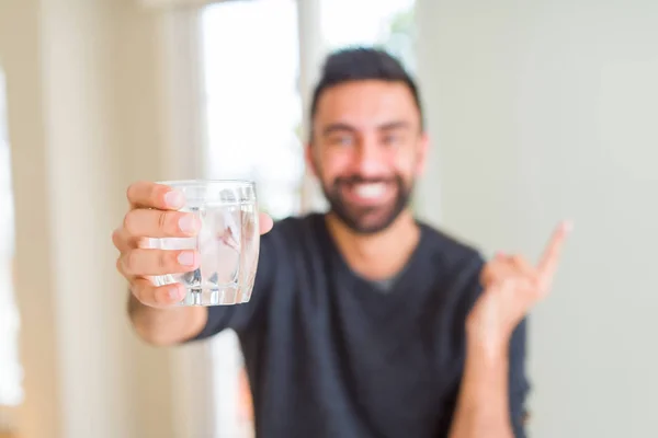 Bonito Homem Hispânico Bebendo Copo Fresco Água Muito Feliz Apontando — Fotografia de Stock