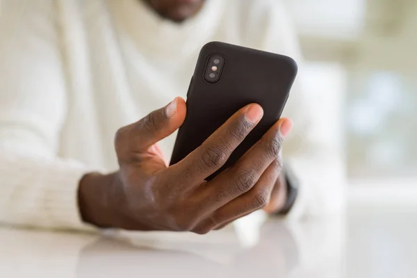 Fechar as mãos do homem africano usando smarpthone — Fotografia de Stock