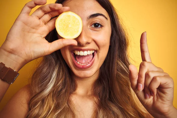 Ung Vacker Kvinna Som Håller Citron Ögat Över Gul Isolerad — Stockfoto