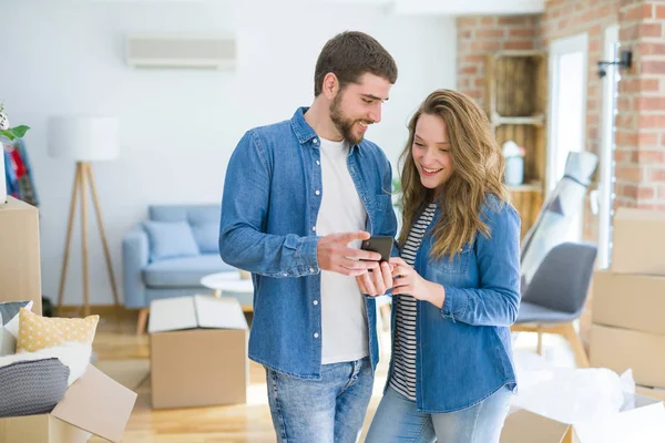 Junges Paar Zieht Mit Smartphone Kartons Ein Neues Haus — Stockfoto