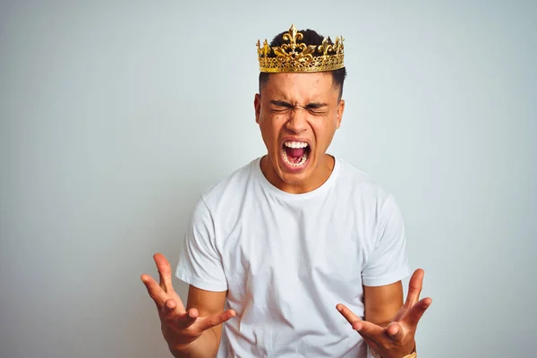 年轻的巴西男子戴着王冠站在孤立的白色背景庆祝疯狂和疯狂的成功与手臂抬起和闭上眼睛尖叫兴奋 优胜者概念 — 图库照片