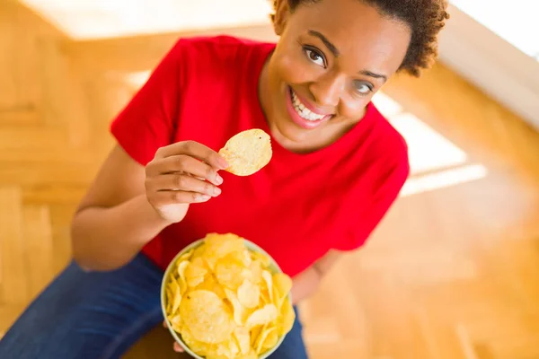 Ung vacker afroamerikanska kvinna med afro hår äta chi — Stockfoto