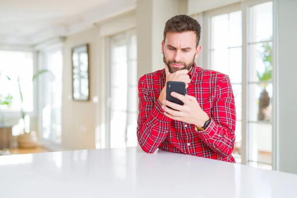 Yakışıklı Bir Adam Akıllı Telefon Kullanıyor Ciddi Bir Yüz Soru — Stok fotoğraf