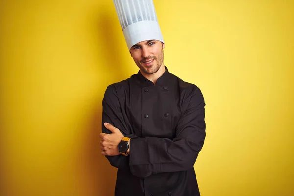 年轻的厨师男子穿着制服和帽子站在孤立的黄色背景幸福的脸微笑与交叉的手臂看着相机 积极的人 — 图库照片