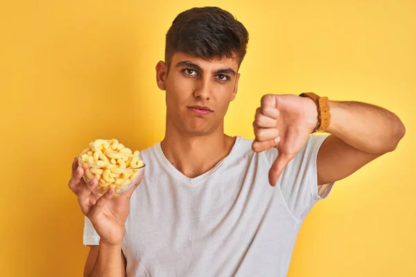 Jovem Indiana Segurando Tigela Com Milho Extrudado Sobre Fundo Amarelo — Fotografia de Stock