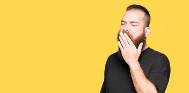 Rahat t-shirt giyen genç sarışın adam el ağzıyla kapsayan yorgun esneme sıkılmış. Restless ve uyku hali.