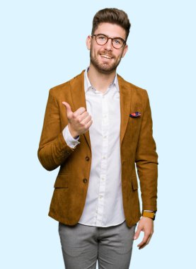 Hareketi el ile mutlu yaşasın yapıyor gözlüklü genç yakışıklı iş adamı. Başarı gösteren kameraya bakarak ifade onaylama.