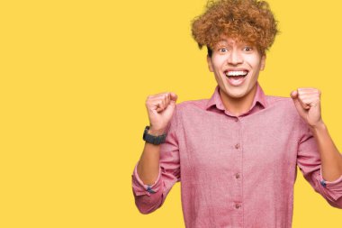 Afro saçlı genç yakışıklı iş adamı şaşırmış kutluyor ve kollarını kaldırdı ve gözleri açık başarı için şaşırttı. Kazanan kavramı.